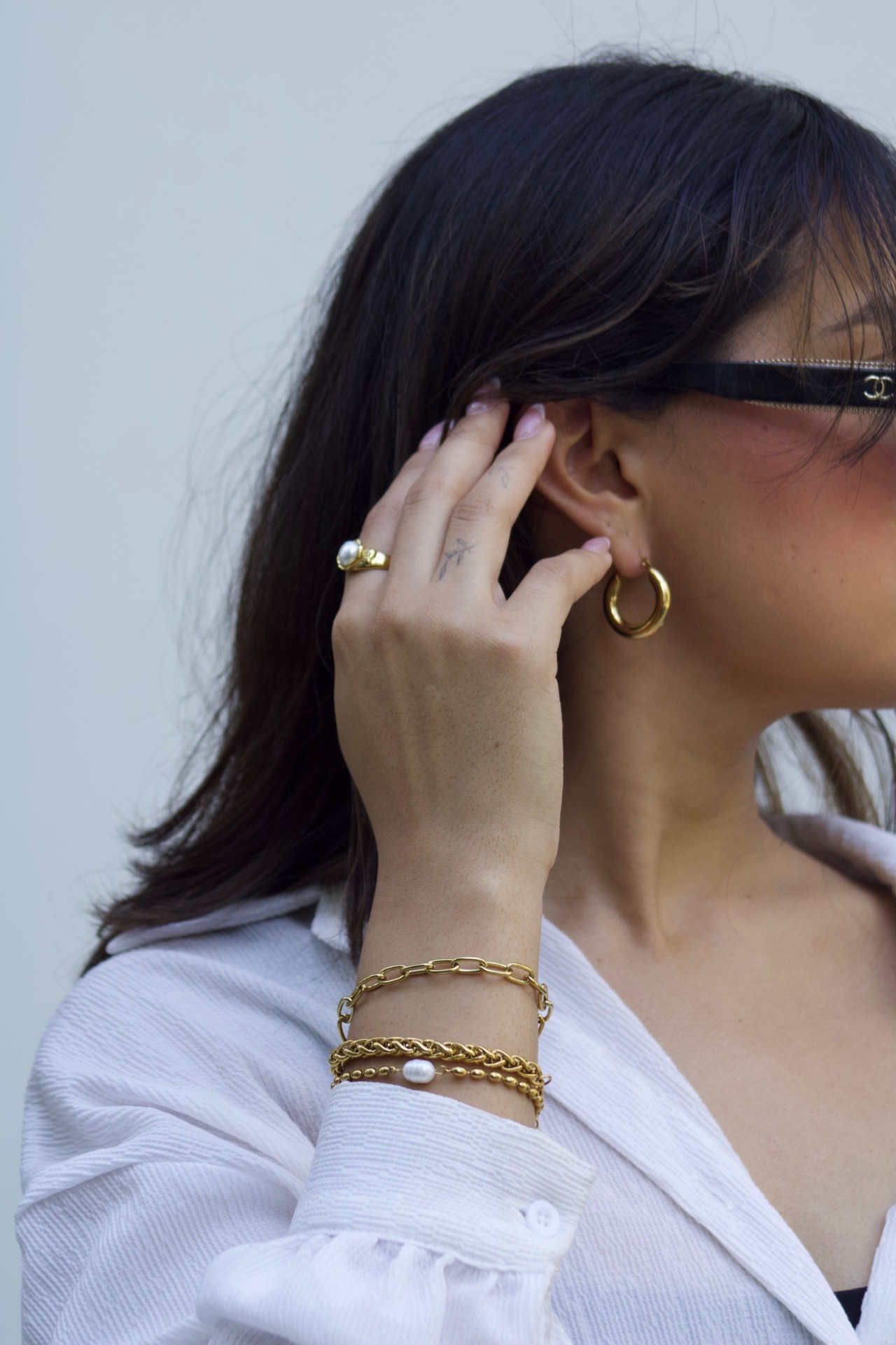 Modelo usando aretes, pulseras y anillo de Tulia joyería